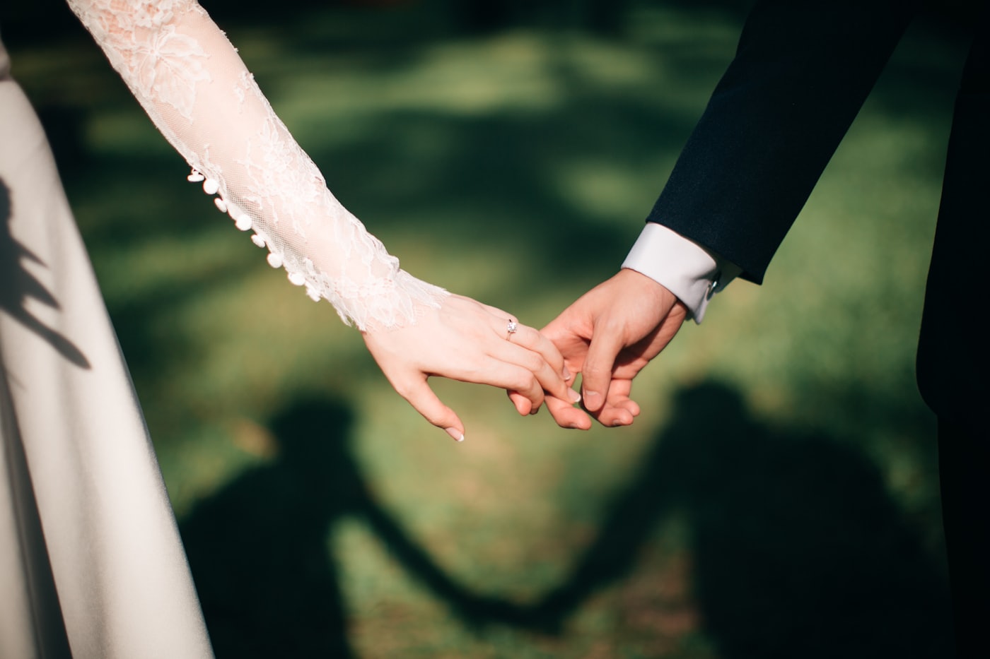 Mains d'un couple enlacées lors d'un entretien de préparation de mariage